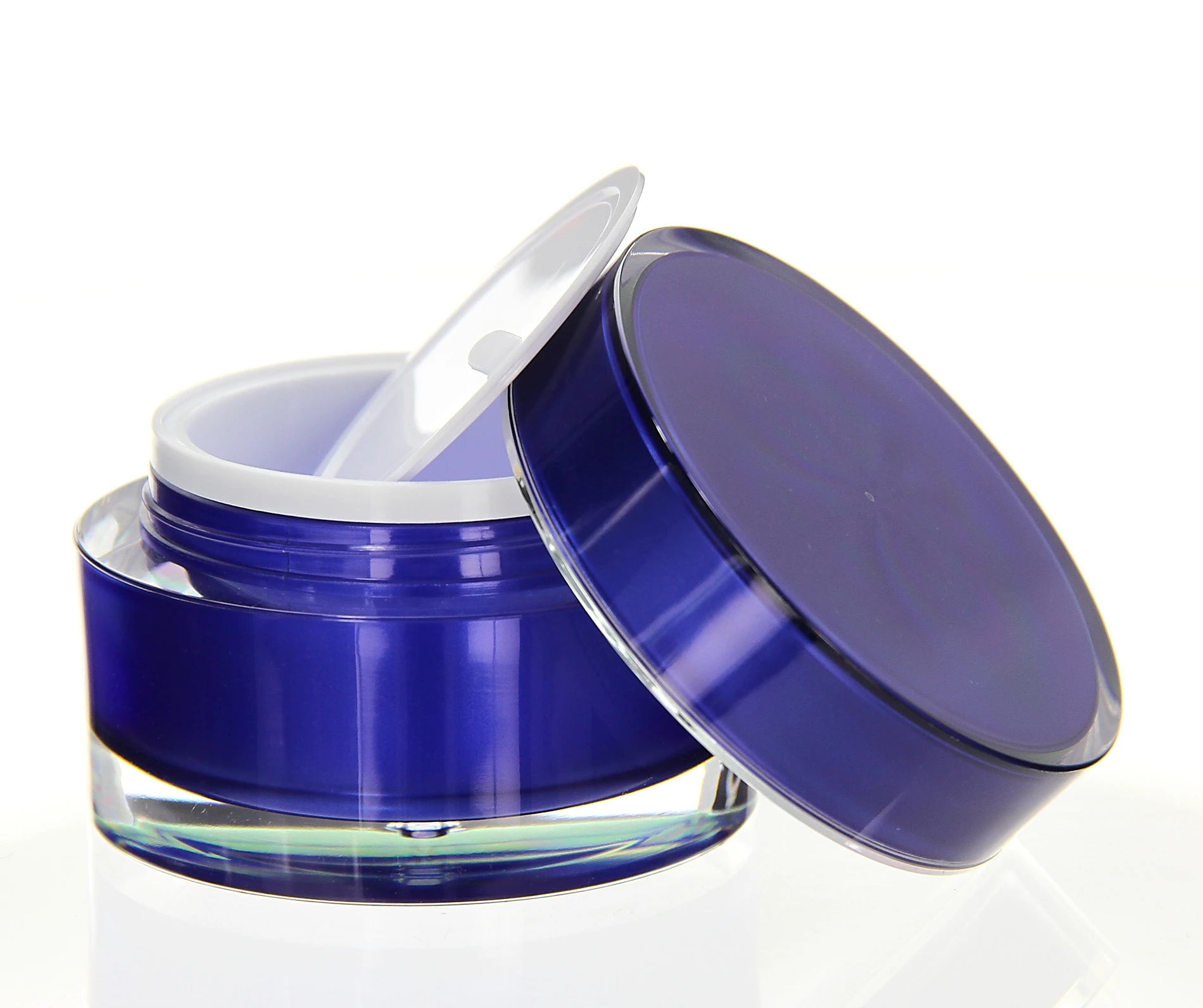 Open 50ml blue acrylic jar with unscrewed lid and white inner disc on white background
