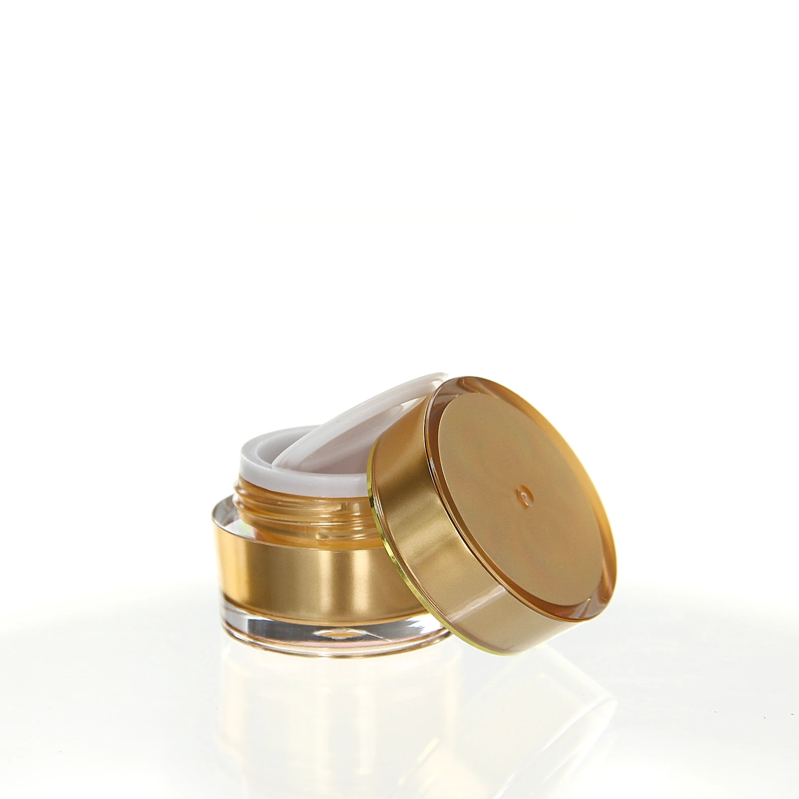 Open 5ml cream jar with glossy gold shell and white sealing disc on light pedestal