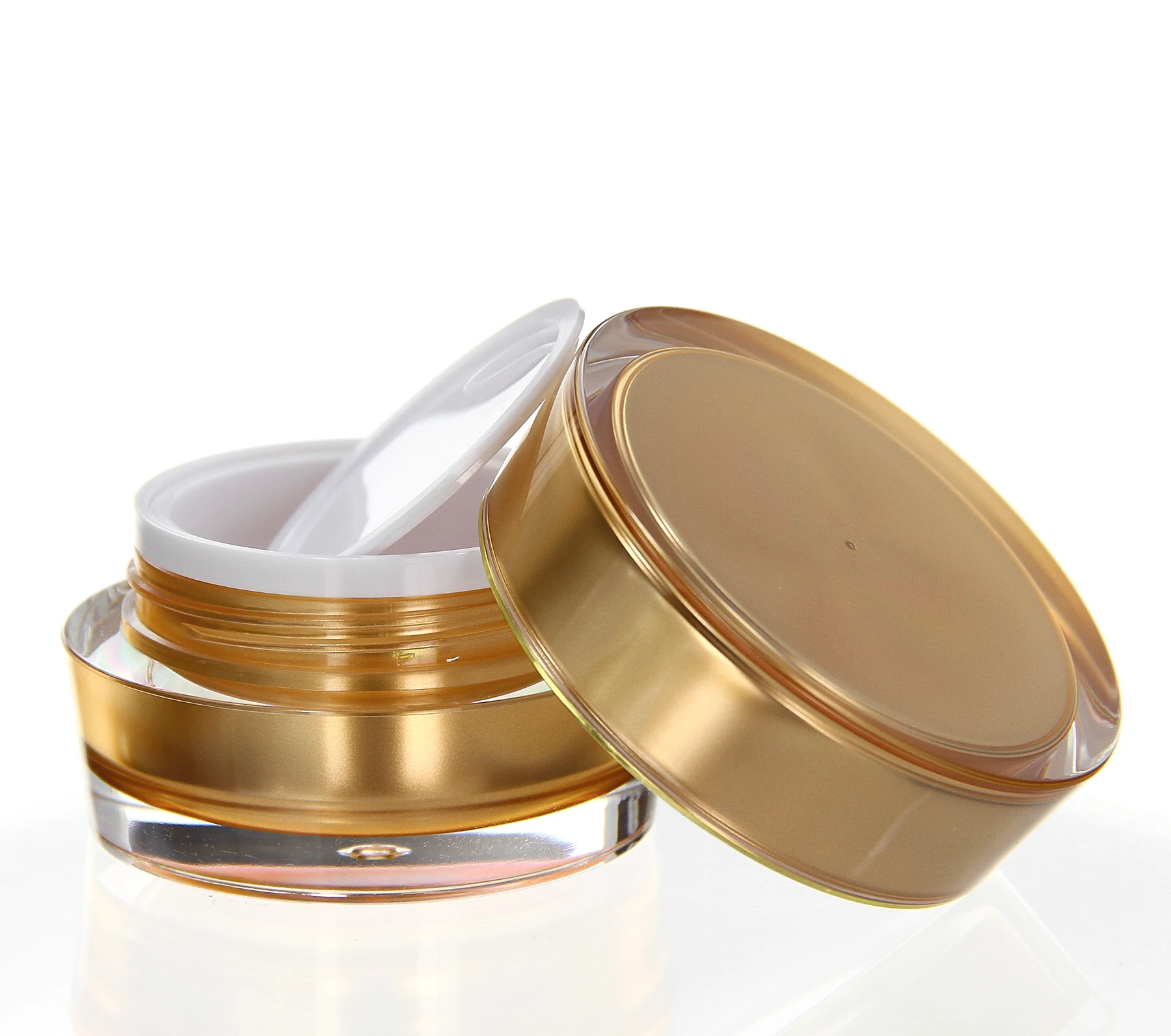 Open 15ml acrylic jar in gold with unscrewed lid and white sealing insert on light background
