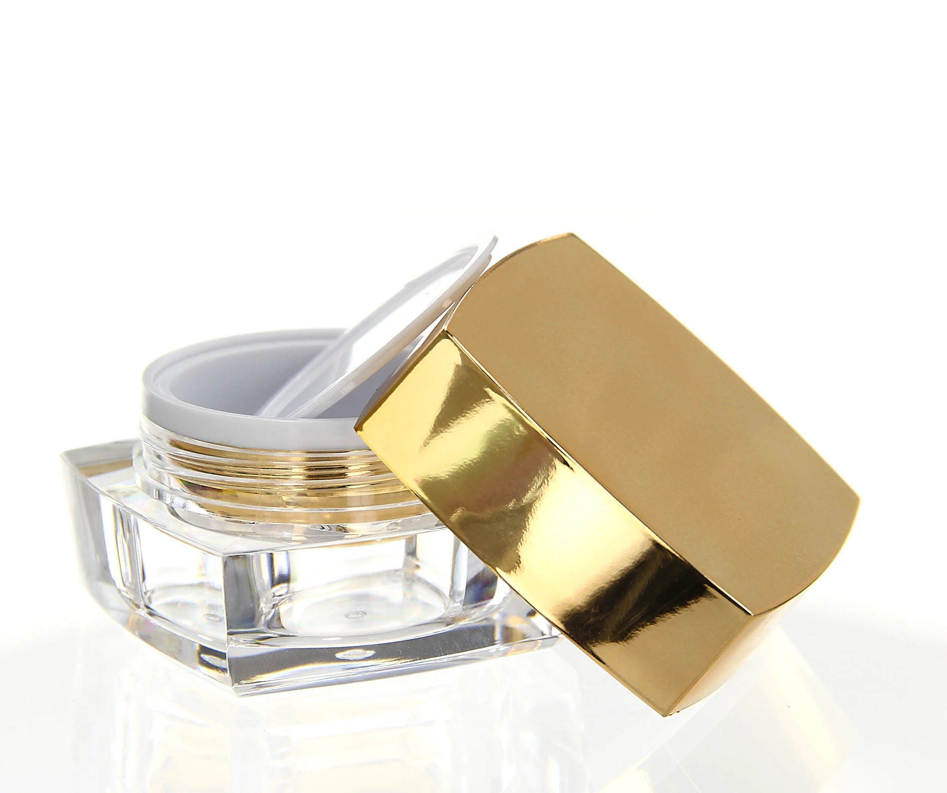 Open 15ml acrylic jar in glossy gold finish with white inner seal and clear base on light background