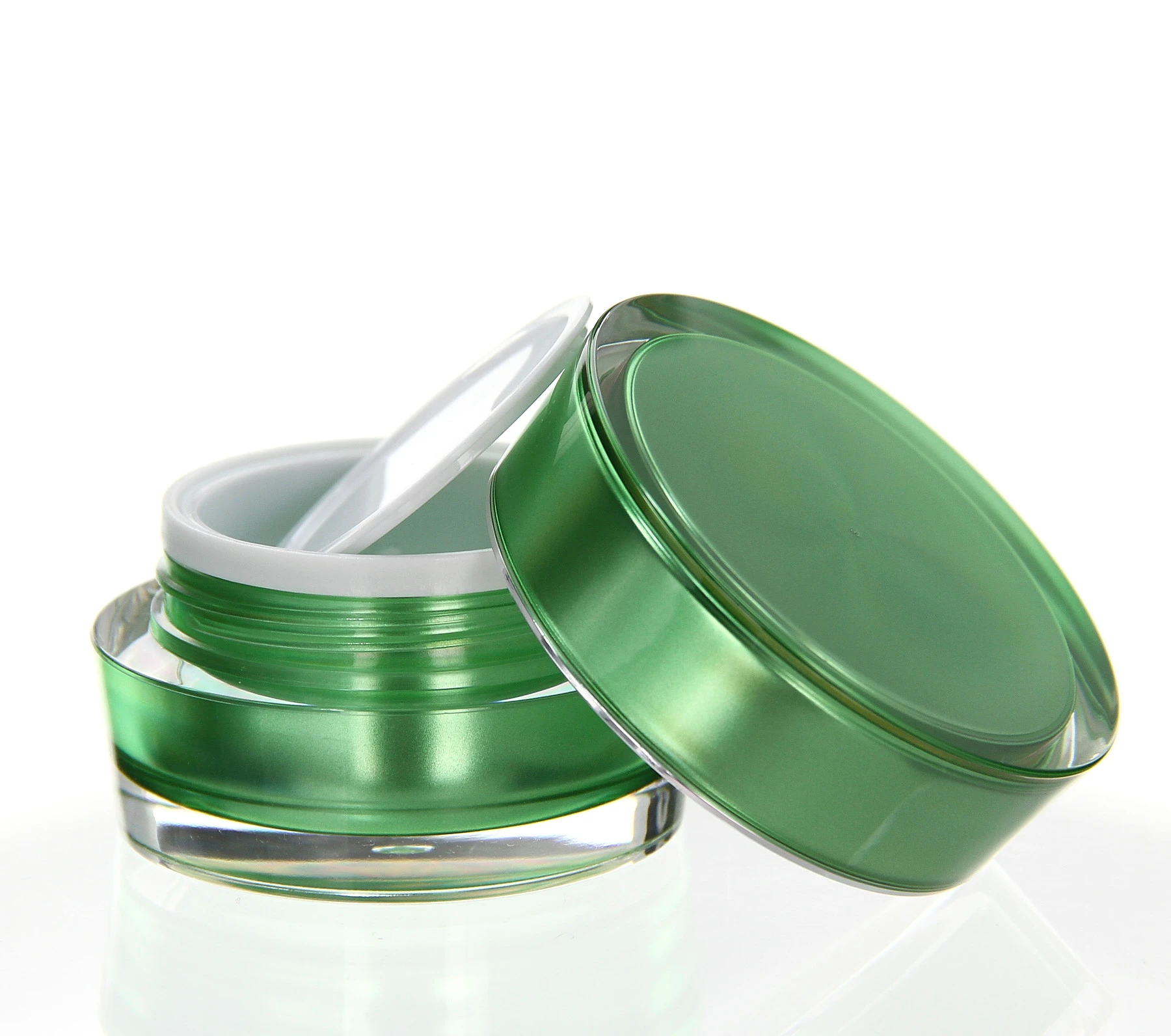 Open 15ml acrylic jar in glossy green with white inner disc on light pedestal