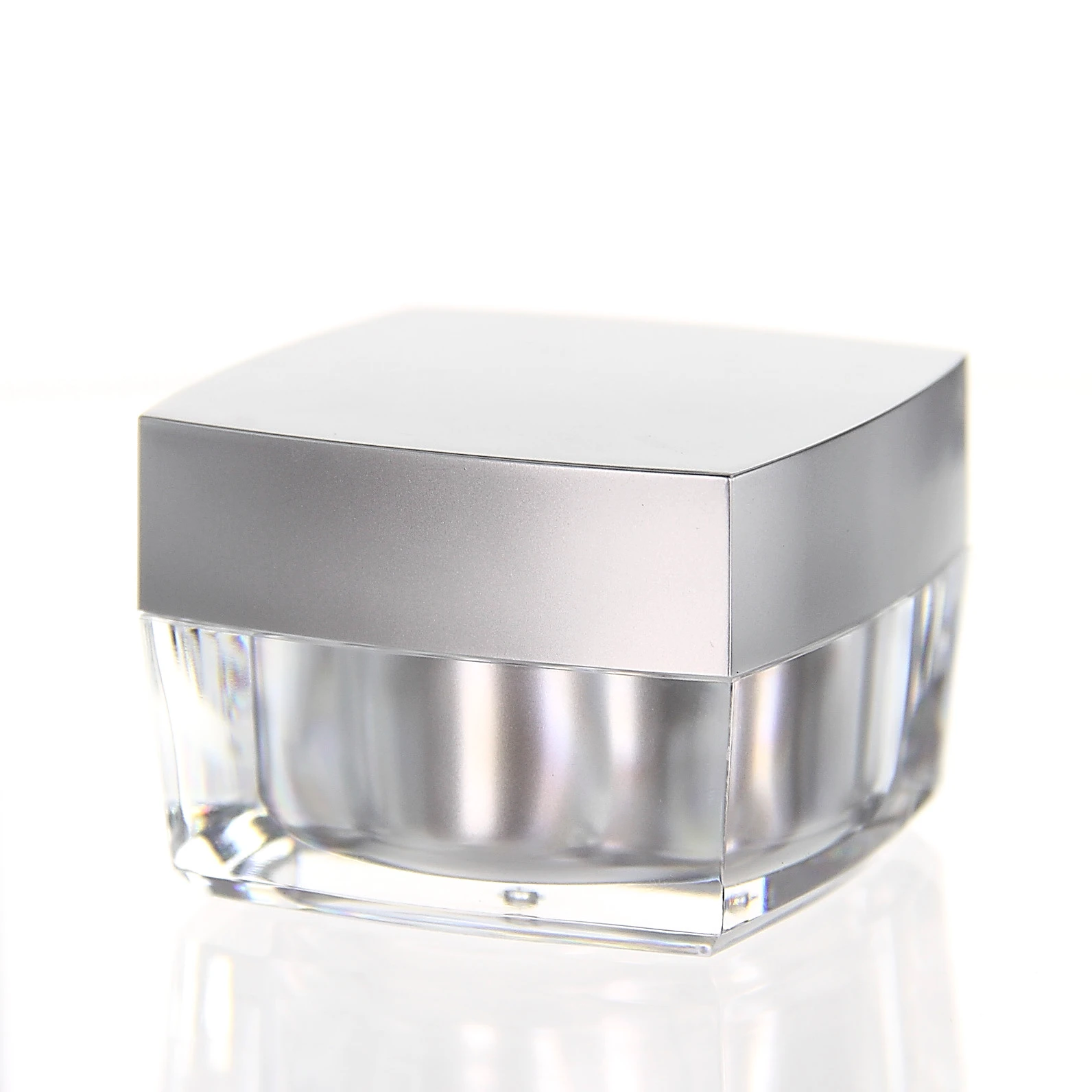 Closed 50ml cosmetic jar in glossy silver with clear outer shell on light background