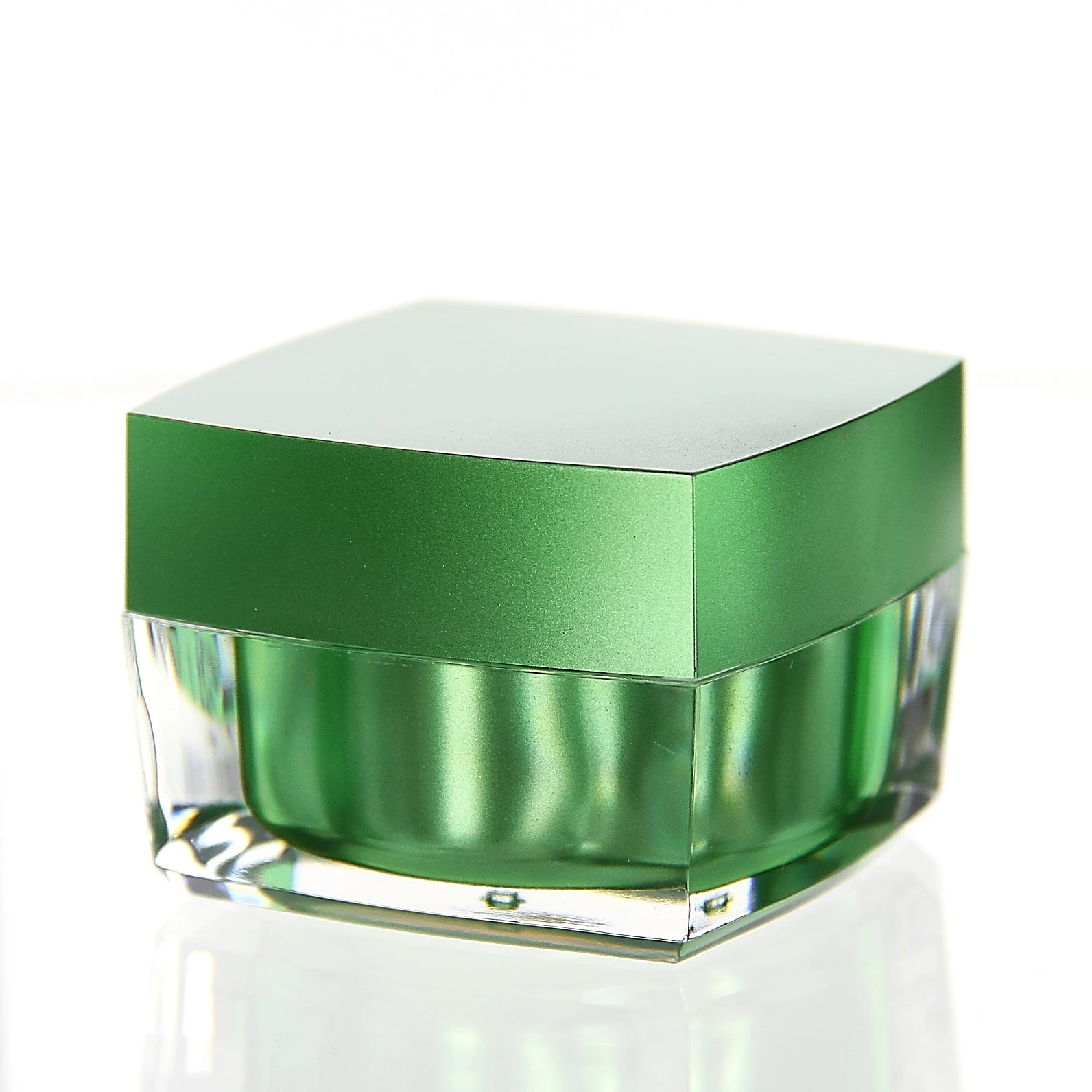 Closed 50ml cosmetic jar in glossy green with clear acrylic base on light background