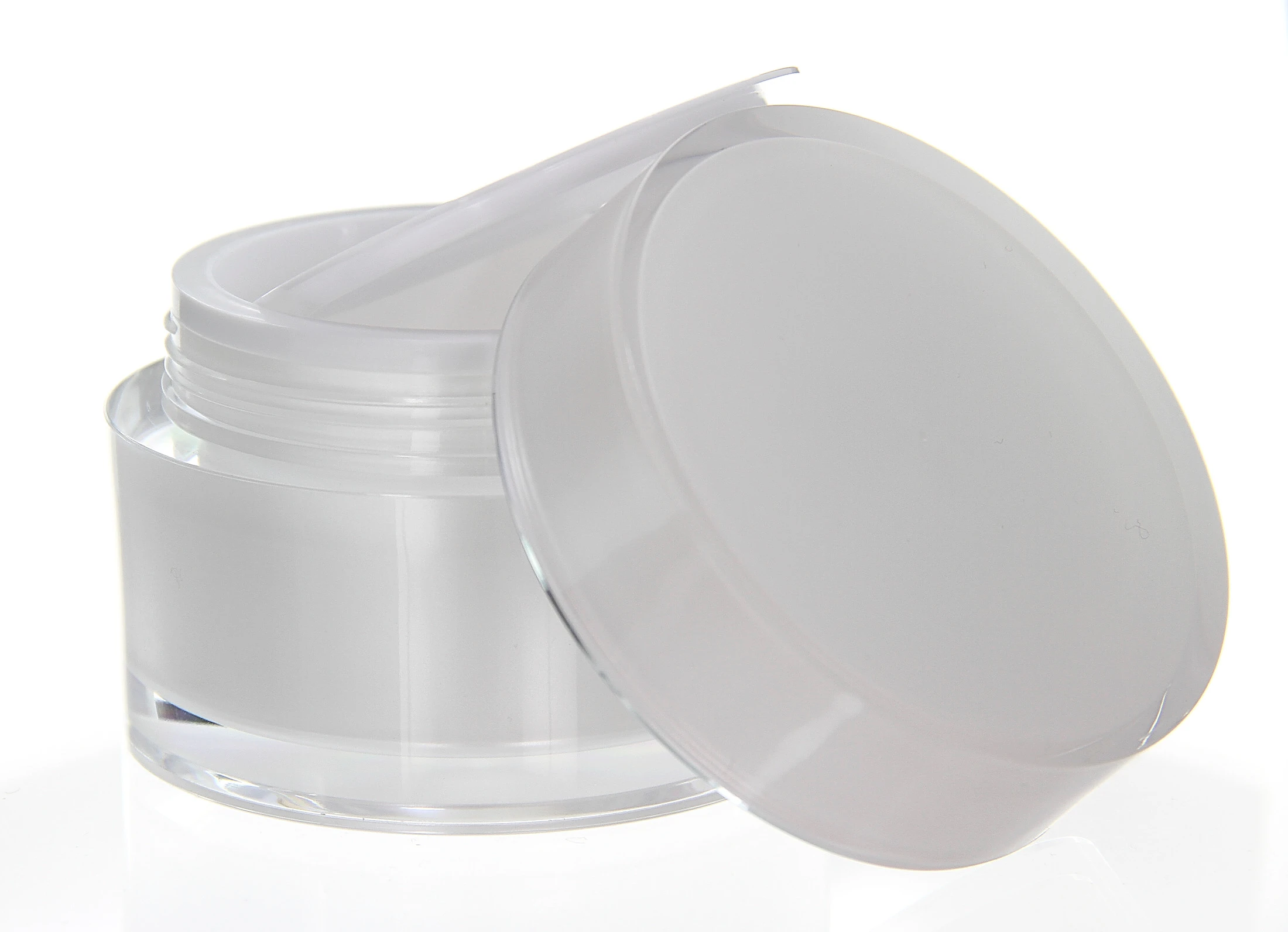 Open 100ml acrylic jar in pearlescent design with white sealing disc on light pedestal